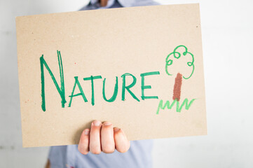 Unrecognizable person holding a sign supporting nature