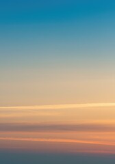 Naklejka premium Vibrant sunset sky with blue-orange gradient, minimal clouds below, clean background, high resolution, peaceful mood. 