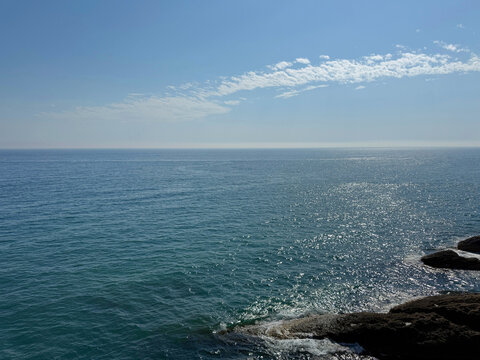 Blue shiny sea, clear sky and rocky Mediterranean coast.
