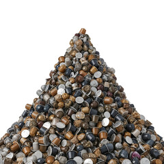 A large pile of used coffee capsules in various colors and materials, arranged in a conical shape against a transparent background.