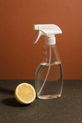 A refreshing lemon and a cleaning spray bottle against a simple background, symbolizing purity, freshness and cleanliness