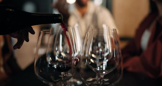 Pouring, liquid and serving alcohol in pub, night or bartender with bottle for order, glass or wine. Preparing, drink and person with liquor for social event, hospitality and server with beverage