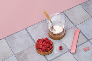 Collagen powder in glass with raspberries for health and beauty. Dietary supplement for skin, hair...
