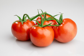 Fresh ripe tomatoes on vine isolated on white background