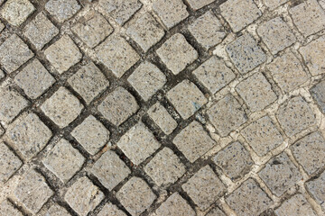textured stone pavement with square cobblestones arranged in a diagonal pattern