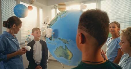 Science Lesson: Primary School Children Studying Renewable Energy. Female Teacher Educating Diverse...