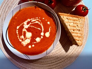 A photo of a bowl of red tomato cream soup