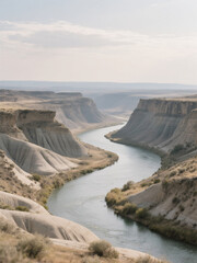 A tranquil river winds through a canyon with steep, layered rock formations and sparse vegetation under a soft, overcast sky.
