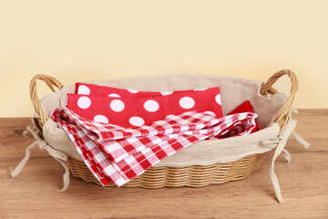 
Picnic basket with checkered towels on wooden table