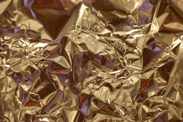 Shimmering golden foil with intricate textures creates a dynamic visual effect in a bright setting
