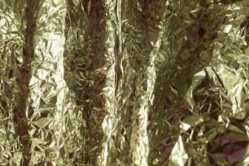 Shimmering gold foil creates a textured surface reflecting light in an artistic display