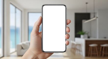Hand holds up a modern frameless smartphone mockup with blank white screen indoors.