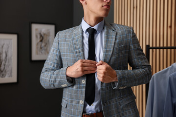 Man tying stylish necktie at home, closeup