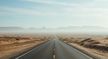 Fototapeta premium Isolated desert highway leading into an endless, misty distance beneath a cloudless sky. Copy space
