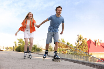 Happy couple roller skating together on street