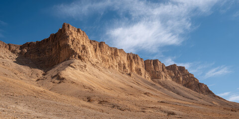 Naklejka premium Dry rocky basin with sheer cliff walls under blue sky