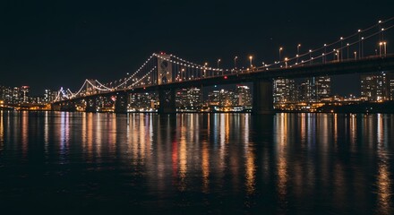 Fototapeta premium Illuminated Bridge with City Skyline Reflected on Water at Night