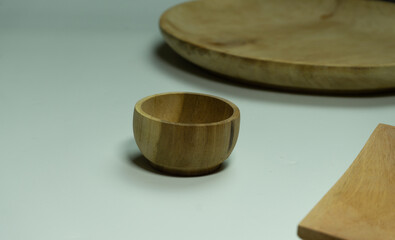 Wooden bowl and plate set on white background, clean flat lay with organic texture, suitable for branding, packaging, or minimal food presentation