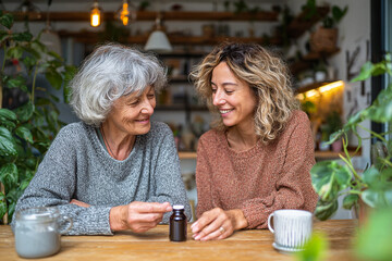 Two women discuss medication indoors. Shot for editorial, design, or marketing.