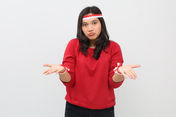 Indonesian woman with red and white ribbon celebrating Indonesian independence day standing with...