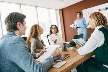 Obraz premium Diverse business team collaborating in a modern office while discussing new strategies during a professional team meeting