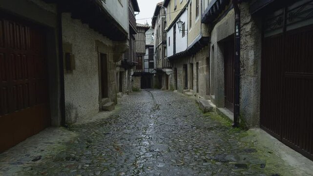 Empty cobblestone alley in La Alberca, Spain after rain. Ideal for travel, architecture, and European heritage themes.