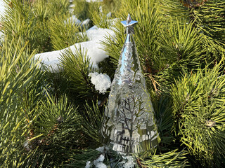 Christmas ornament on pine tree covered snow.