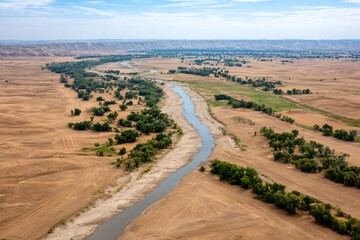 River flowing through dry fields in summer, aerial view of cultivated landscape