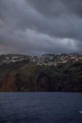 Hillside village above dark sea Vertical