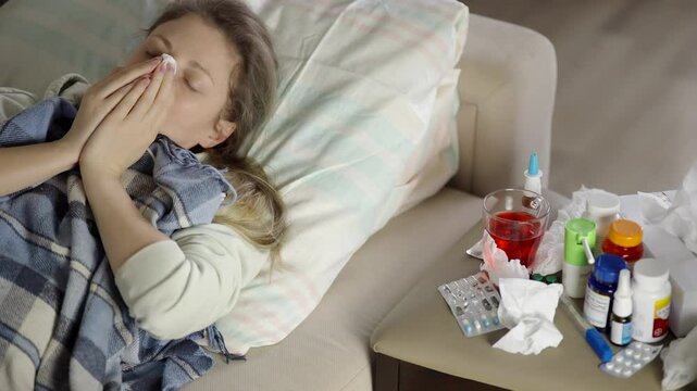 Sick Patient Lying In Bed Blowing Nose With Napkin. Person Suffering From Flu Or Cold. Seasonal Virus Infection