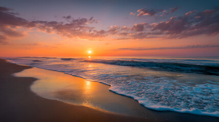 Obraz premium Golden sunrise illuminating ocean waves on sandy beach
