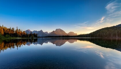 serene mountain reflection in calm lake at dawn under blue sky
