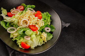 Pasta salad green leaf lettuce, tomato, pasta, onion fresh delicious gourmet food background on the table rustic food top view copy space keto and paleo diet vegan and vegetarian food