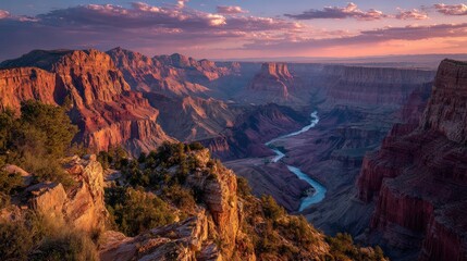 Stunning sunset over the Grand Canyon with dramatic rock formations and a winding river below, showcasing nature's breathtaking beauty.