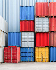 Fototapeta premium Stacked colorful shipping containers arranged in neat rows, showcasing industrial storage and transport infrastructure.
