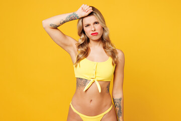 Young ill sick tired exhausted sad woman wear bikini swimsuit rest near hotel pool put hand on...