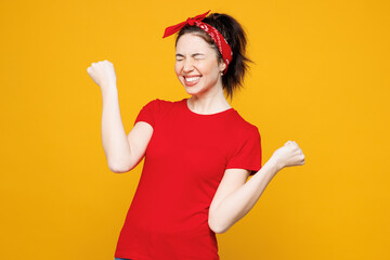 Young overjoyed excited woman she wearing red t-shirt casual clothes doing winner gesture celebrate...