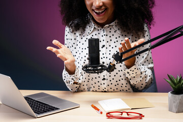 Enthusiastic African American speaker recording podcast in home studio