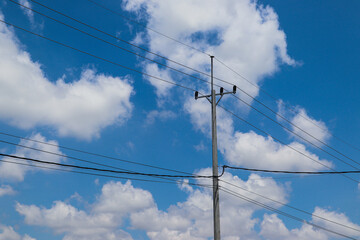 Obraz premium Tall electric pole connected with cables, essential power supply infrastructure component