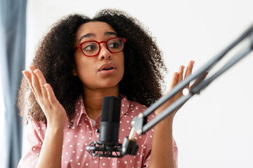 Young woman recording a podcast and gesturing with hands