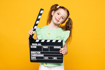 Little smiling fun kid child girl 8-9 years old wear green t-shirt hold in hand classic black film...