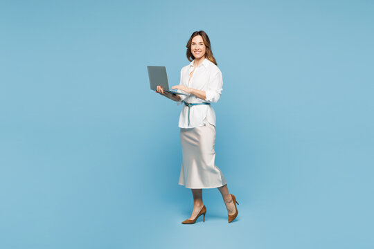 Full body young employee IT business woman corporate lawyer wear shirt classic formal clothes work in office hold use laptop pc computer isolated on plain pastel light blue background studio portrait.