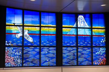 Stained glass art featuring Mount Fuji. Seagull flying over water, waves, and floral design....