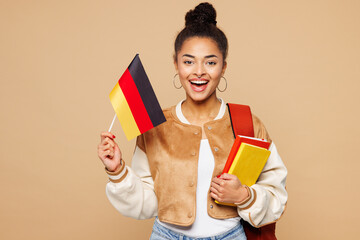 Young smiling fun happy smart girl student wear casual clothes backpack bag hold books German flag...