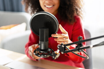 Podcaster adjusting microphone preparing for recording podcast selective focus on hands closeup