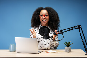 Young African American woman recording podcast in professional studio
