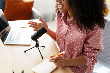 Content creator recording podcast using condenser microphone and laptop
