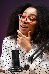 Young African American woman recording podcast thinking with hand on chin
