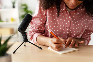 Podcaster writing notes while recording podcast episode