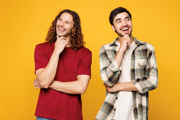 Young smiling happy two friends buddies men wear casual clothes together put hand prop up on chin,...